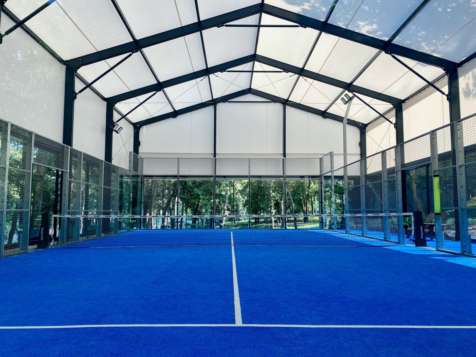 Empty covered padel court with blue turf